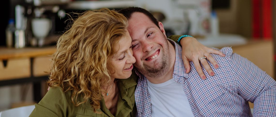 Woman hugging young man with Down Syndrome